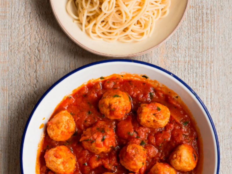 Bowl of money-saving low-meat meatballs and bowl of spaghetti